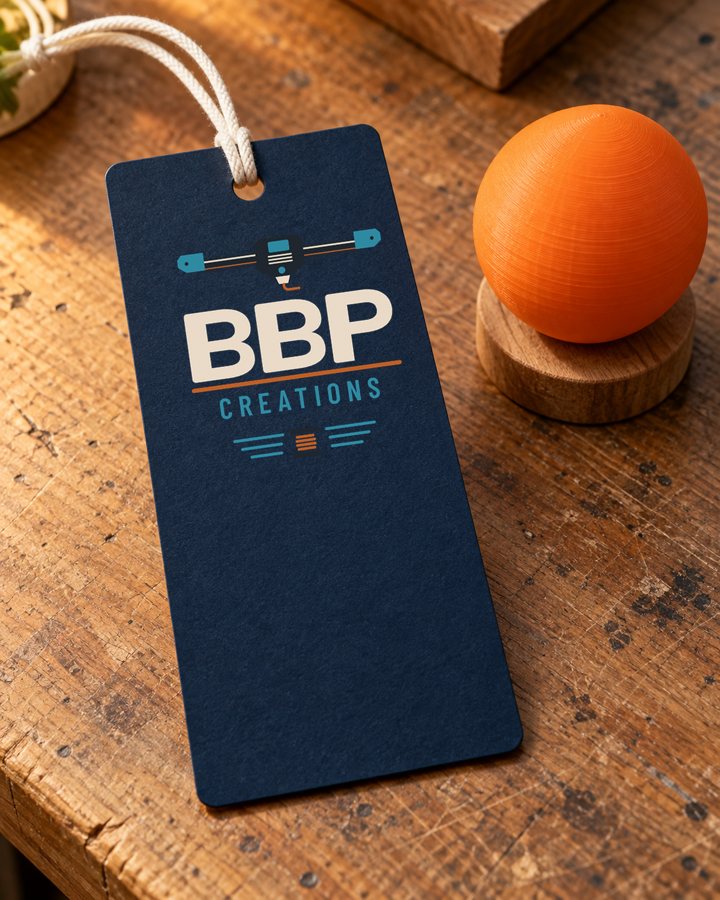 A navy hang tag with the BBP logo next to a printed orange sphere on a wooden bench